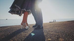 Young couple dancing Latin Bachata on sunset background